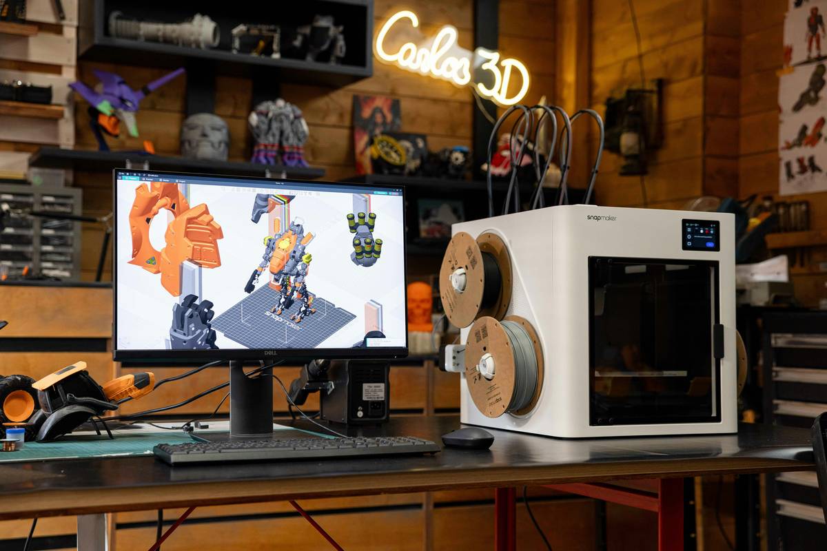 Student completing online 3d printing courses while testing printed prototype on desk